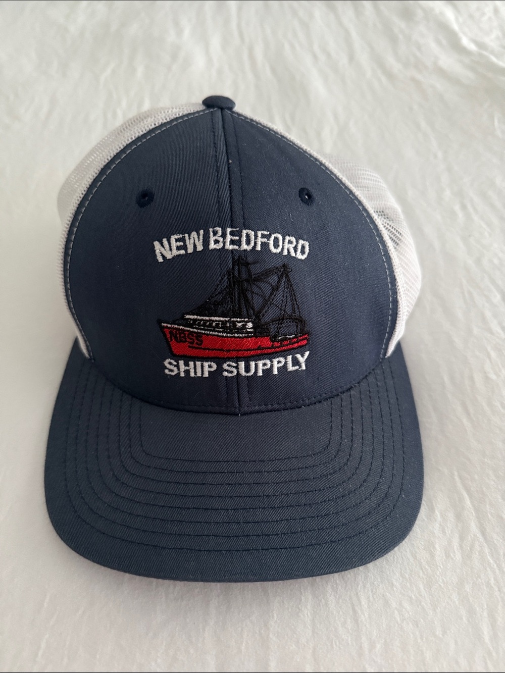 New Bedford Ship Supply Navy & White Trucker Hat with Red Boat Embroidery
